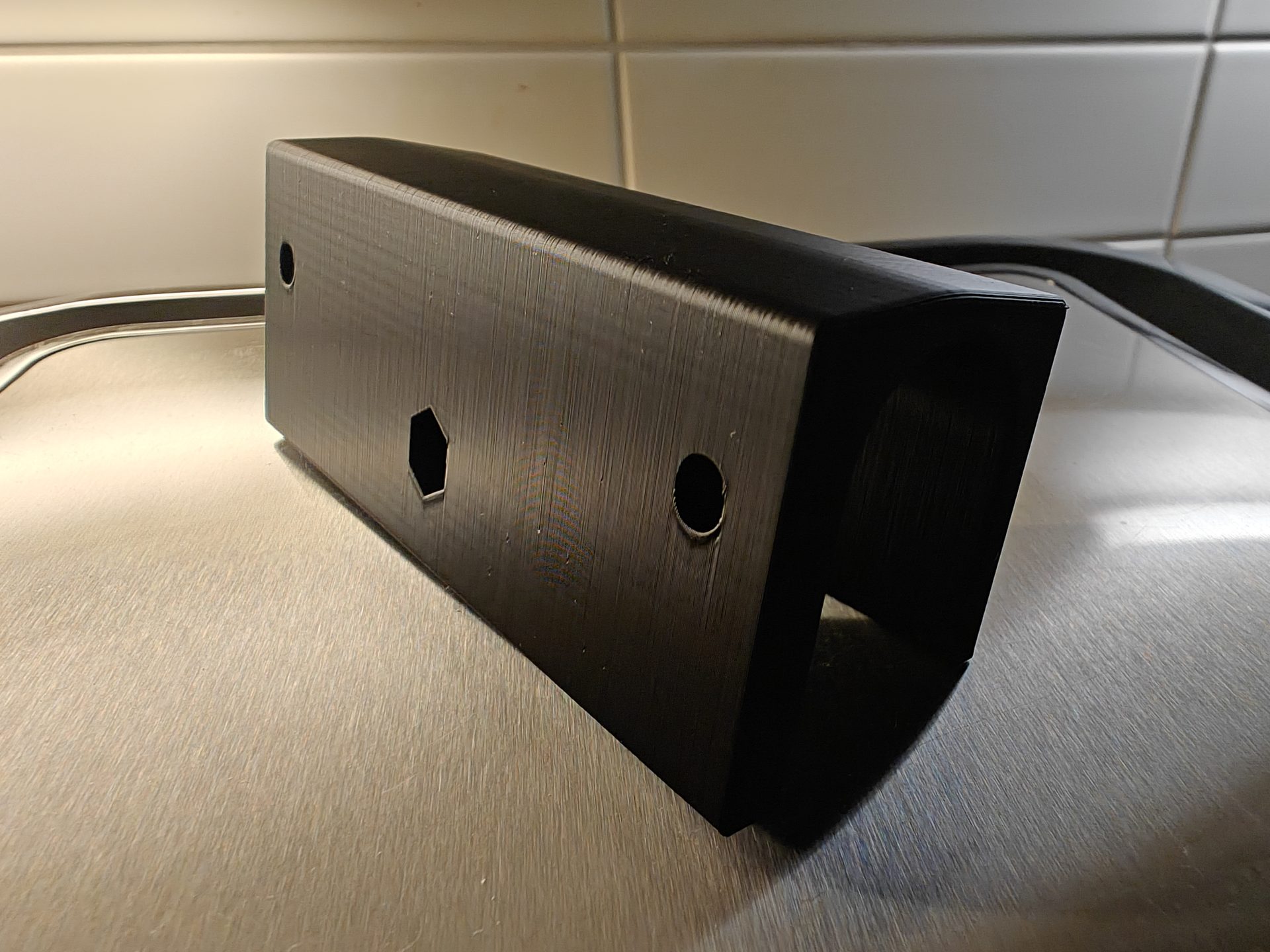 Musta suorakulmio-osa teräspinnalla